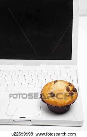 Close-up of cupcake and laptop View Large Photo Image Stock Photo - Close-up of cupcake and laptop. Fotosearch