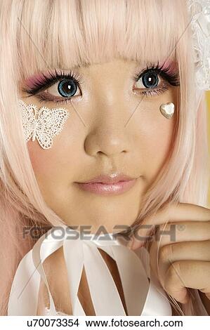 Close-up of cute young woman dressed as a doll with hand on chin View Large Photo Image Picture - Close-up of cute young woman dressed as a doll with hand on chin. Fotosearch