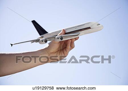 Close-up of hand flying toy airplane against clear sky View Large Photo Image Stock Photo - Close-up of hand flying toy airplane against clear sky. Fotosearch
