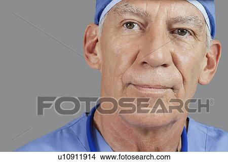 Close-up of senior male doctor over gray background View Large Photo Image Picture - Close-up of senior male doctor over gray background. Fotosearch