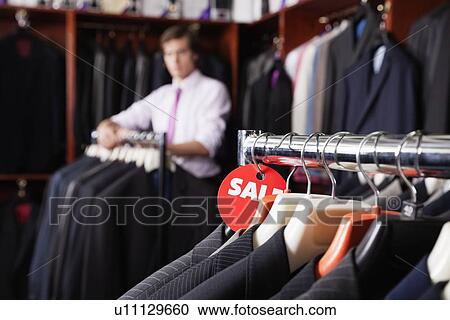 Close-up of suits hanging on rack with price tag in store View Large Photo Image Stock Image - Close-up of suits hanging on rack with price tag in store. Fotosearch
