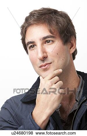 Stock Photo - Close-up of young man thinking against white background. Fotosearch