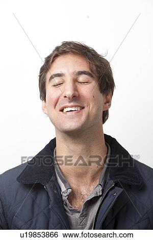 Close-up of young man with eyes closed smiling against white background View Large Photo Image Stock Photograph - Close-up of young man with eyes closed smiling against white background. Fotosearch