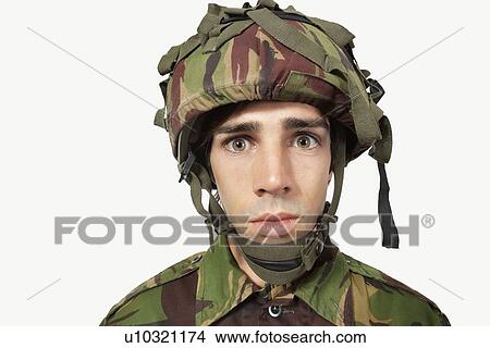 Close-up portrait of young soldier staring against gray background View Large Photo Image Picture - Close-up portrait of young soldier staring against gray background. Fotosearch