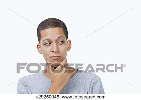 Confused young mixed race man with hand on chin against white background View Large Photo Image Stock Photography - Confused young mixed race man with hand on chin against white background. Fotosearch