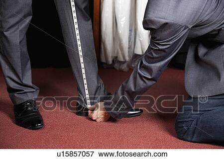 Cropped image of tailor measuring man's trouser in store View Large Photo Image Stock Photo - Cropped image of tailor measuring man's trouser in store. Fotosearch