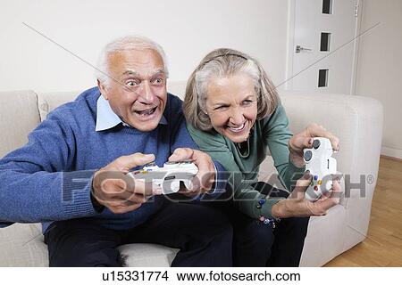 Picture - Enthusiastic senior couple playing video game at home. Fotosearch