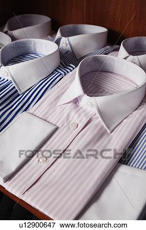 Folded shirts on shelf in a clothing store View Large Photo Image Stock Photo - Folded shirts on shelf in a clothing store. Fotosearch