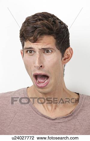 Frightened young man screaming against white background View Large Photo Image Stock Image - Frightened young man screaming against white background. Fotosearch