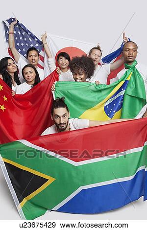 Group of multi-ethnic friends holding various national flags against white background View Large Photo Image Stock Photo - Group of multi-ethnic friends holding various national flags against white background. Fotosearch