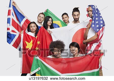 Group of multi-ethnic friends posing with various national flags against white background View Large Photo Image Stock Image - Group of multi-ethnic friends posing with various national flags against white background. Fotosearch