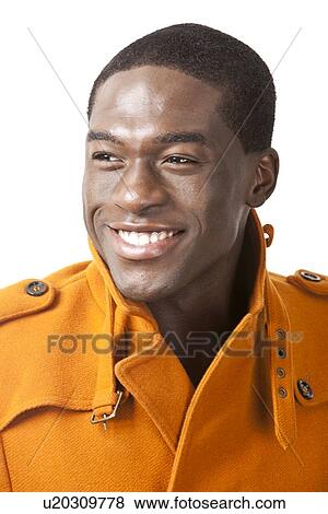 Happy young man in orange trench coat smiling against white background View Large Photo Image Stock Photo - Happy young man in orange trench coat smiling against white background. Fotosearch
