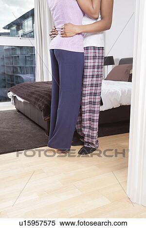 Low section of young couple embracing beside bed View Large Photo Image Stock Photography - Low section of young couple embracing beside bed. Fotosearch