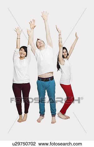 Stock Image - Multi-ethnic friends in casuals with arms raised standing together over white background. Fotosearch