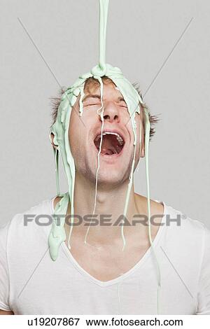 Paint falling on young Caucasian man against gray background View Large Photo Image Stock Photo - Paint falling on young Caucasian man against gray background. Fotosearch