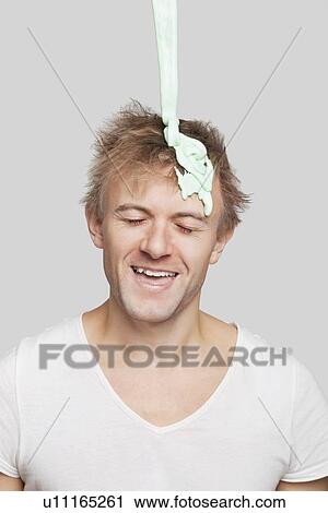Paint falling on young Caucasian man's head against gray background View Large Photo Image Stock Image - Paint falling on young Caucasian man's head against gray background. Fotosearch
