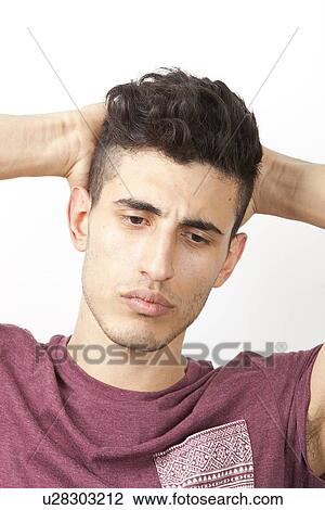 Pensive young Middle Eastern man with hands behind head over white background View Large Photo Image Stock Image - Pensive young Middle Eastern man with hands behind head over white background. Fotosearch