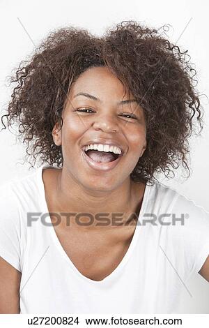 Portrait of a joyful African American young woman laughing against white background View Large Photo Image Picture - Portrait of a joyful African American young woman laughing against white background. Fotosearch