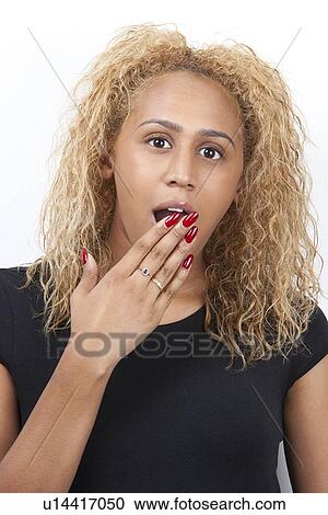 Portrait of amazed young woman with hand over mouth against white background View Large Photo Image Stock Image - Portrait of amazed young woman with hand over mouth against white background. Fotosearch