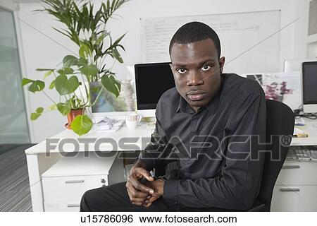 Stock Photograph - Portrait of an African American businessman at office. Fotosearch