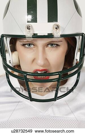 Portrait of an aggressive young woman in football uniform against gray background View Large Photo Image Stock Photo - Portrait of an aggressive young woman in football uniform against gray background. Fotosearch