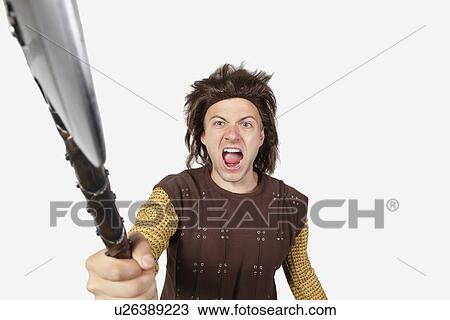 Portrait of angry man in caveman costume holding axe against gray background View Large Photo Image Stock Image - Portrait of angry man in caveman costume holding axe against gray background. Fotosearch
