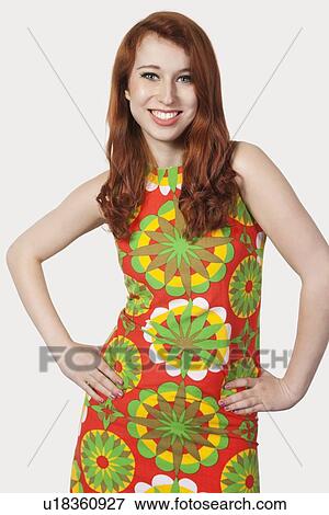 Portrait of beautiful young woman in multicolored dress posing against gray background View Large Photo Image Stock Photo - Portrait of beautiful young woman in multicolored dress posing against gray background. Fotosearch