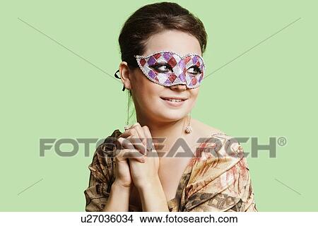 Portrait of beautiful young woman with eye mask day dreaming against green background View Large Photo Image Picture - Portrait of beautiful young woman with eye mask day dreaming against green background. Fotosearch