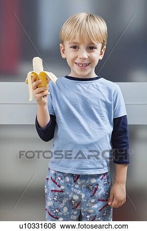Portrait of Caucasian boy in casuals holding banana View Large Photo Image Stock Photo - Portrait of Caucasian boy in casuals holding banana. Fotosearch
