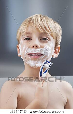 Picture - Portrait of Caucasian boy pretending to shave his face. Fotosearch