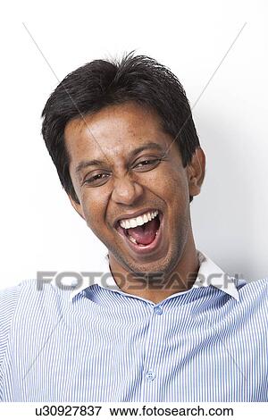 Portrait of cheerful young Indian man against white background View Large Photo Image Stock Photo - Portrait of cheerful young Indian man against white background. Fotosearch