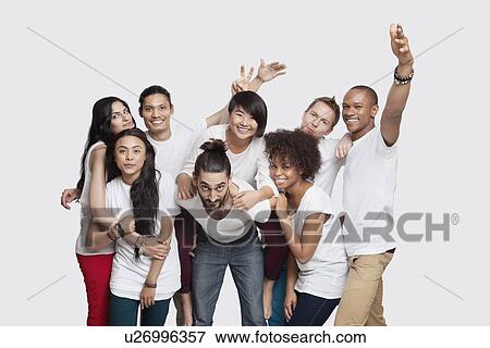 Stock Photo - Portrait of cheerful young multi-ethnic friends posing against white background. Fotosearch
