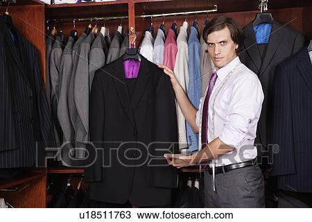 Portrait of confident man showing new suits in store View Large Photo Image Stock Image - Portrait of confident man showing new suits in store. Fotosearch