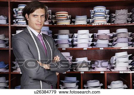 Portrait of confident owner with arms crossed standing against display cabinet View Large Photo Image Stock Photo - Portrait of confident owner with arms crossed standing against display cabinet. Fotosearch