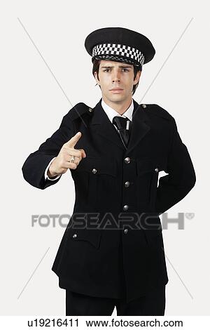 Portrait of confident police officer gesturing against gray background View Large Photo Image Stock Image - Portrait of confident police officer gesturing against gray background. Fotosearch