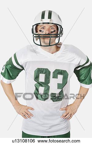 Portrait of confident young man wearing football uniform against gray background View Large Photo Image Stock Photograph - Portrait of confident young man wearing football uniform against gray background. Fotosearch