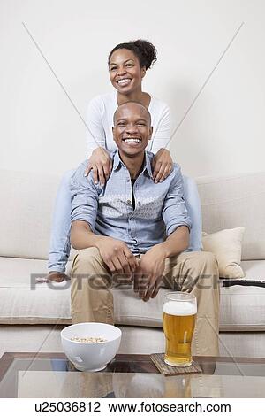 Portrait of excited young African American couple watching TV View Large Photo Image Stock Image - Portrait of excited young African American couple watching TV. Fotosearch