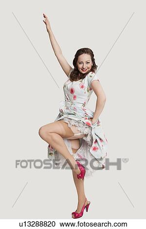 Portrait of fashionable young woman in dress posing against white background View Large Photo Image Stock Image - Portrait of fashionable young woman in dress posing against white background. Fotosearch