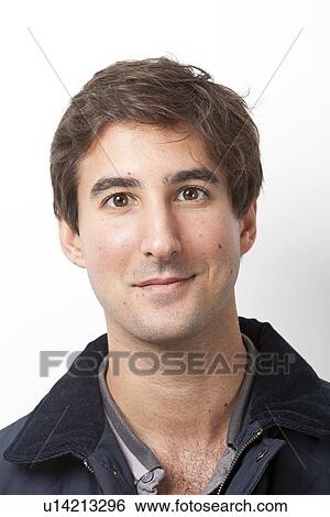 Stock Photograph - Portrait of handsome Middle Eastern young man smiling against white background. Fotosearch