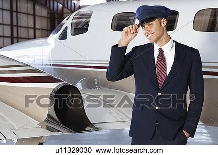 Portrait of handsome young pilot standing in front of private airplane View Large Photo Image Stock Image - Portrait of handsome young pilot standing in front of private airplane. Fotosearch