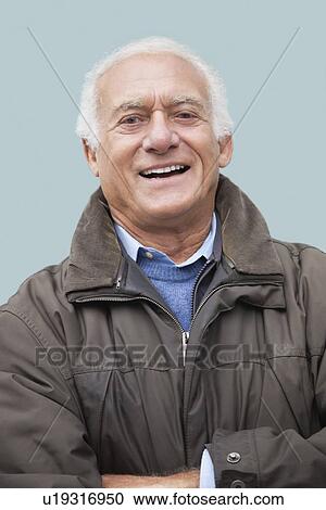 Portrait of happy elderly man against blue background View Large Photo Image Stock Image - Portrait of happy elderly man against blue background. Fotosearch