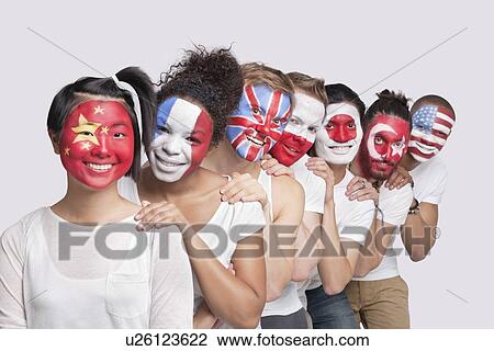 Stock Image - Portrait of happy Multi-ethnic group of friends with various national flags painted on their faces standing against white background. Fotosearch