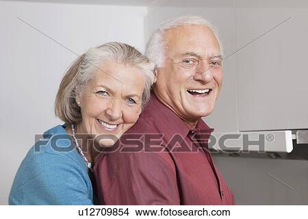 Portrait of happy senior couple at domestic kitchen View Large Photo Image Picture - Portrait of happy senior couple at domestic kitchen. Fotosearch