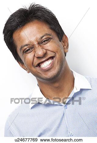 Portrait of happy young Indian man against white background View Large Photo Image Stock Photo - Portrait of happy young Indian man against white background. Fotosearch