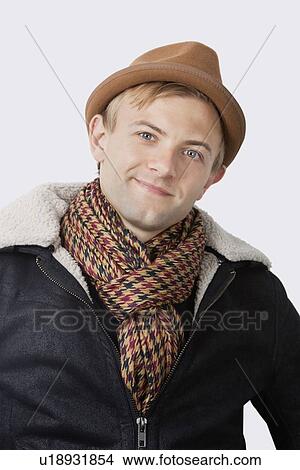 Portrait of happy young man in warm clothing against white background View Large Photo Image Picture - Portrait of happy young man in warm clothing against white background. Fotosearch