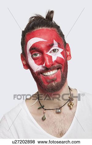 Portrait of happy young man with Turkish flag painted on face against white background View Large Photo Image Stock Photo - Portrait of happy young man with Turkish flag painted on face against white background. Fotosearch