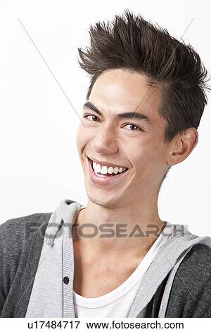 Stock Photo - Portrait of happy young mixed race man against white background. Fotosearch