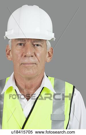 Stock Photography - Portrait of male senior construction worker wearing hard hat over white background. Fotosearch