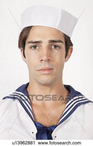 Stock Image - Portrait of sad young man in sailor's uniform against gray background. Fotosearch