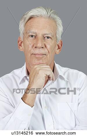 Portrait of senior man with hand on chin over gray background View Large Photo Image Stock Photograph - Portrait of senior man with hand on chin over gray background. Fotosearch
